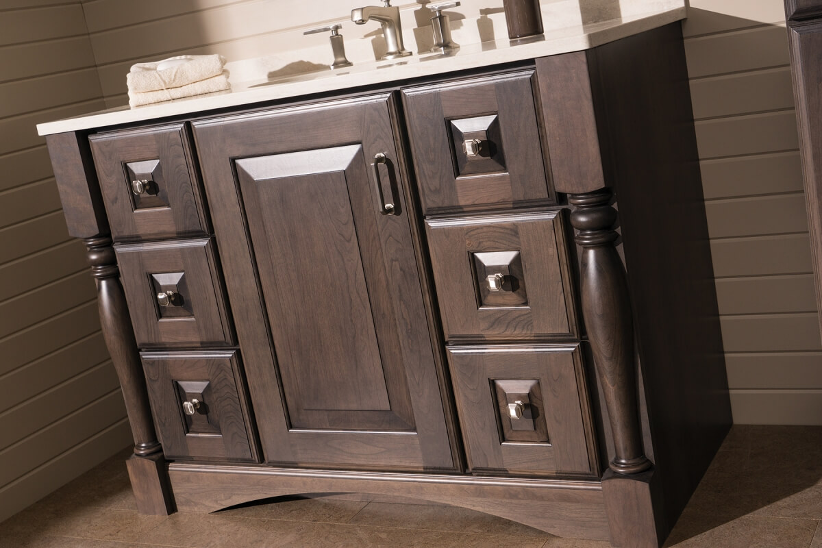 Learn how to design a customized furniture style vanity. This bathroom design features a traditional styled furniture-like vanity with decorative turned posts, raised panel doors, and an elegant toe kick valence.