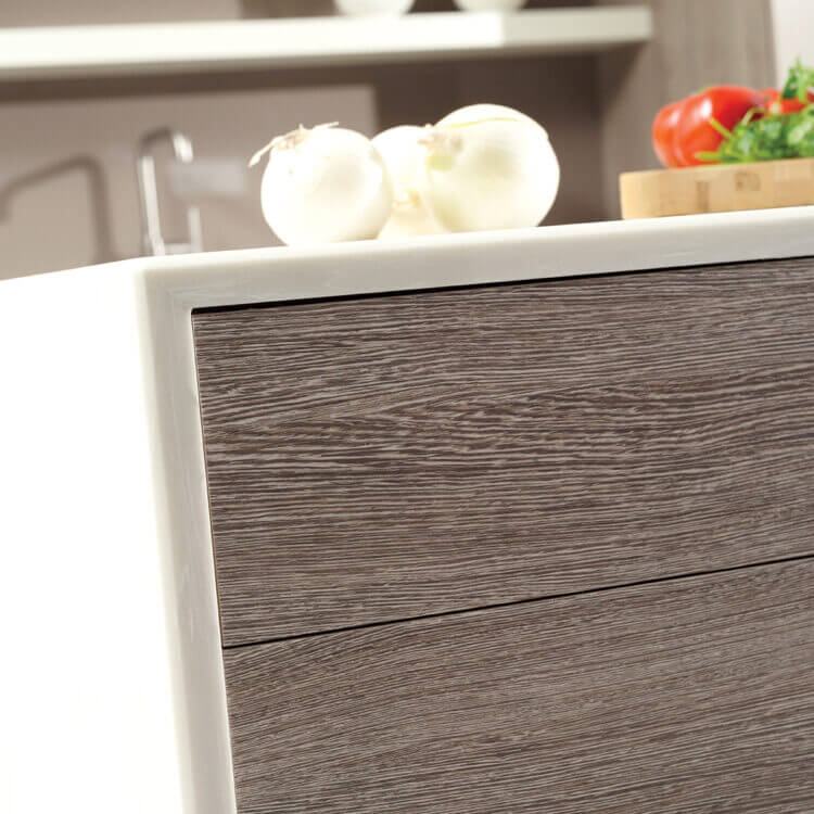 A close up of a contemporary kitchen island with a thin, white waterfall countertop and textured shiplap panels.