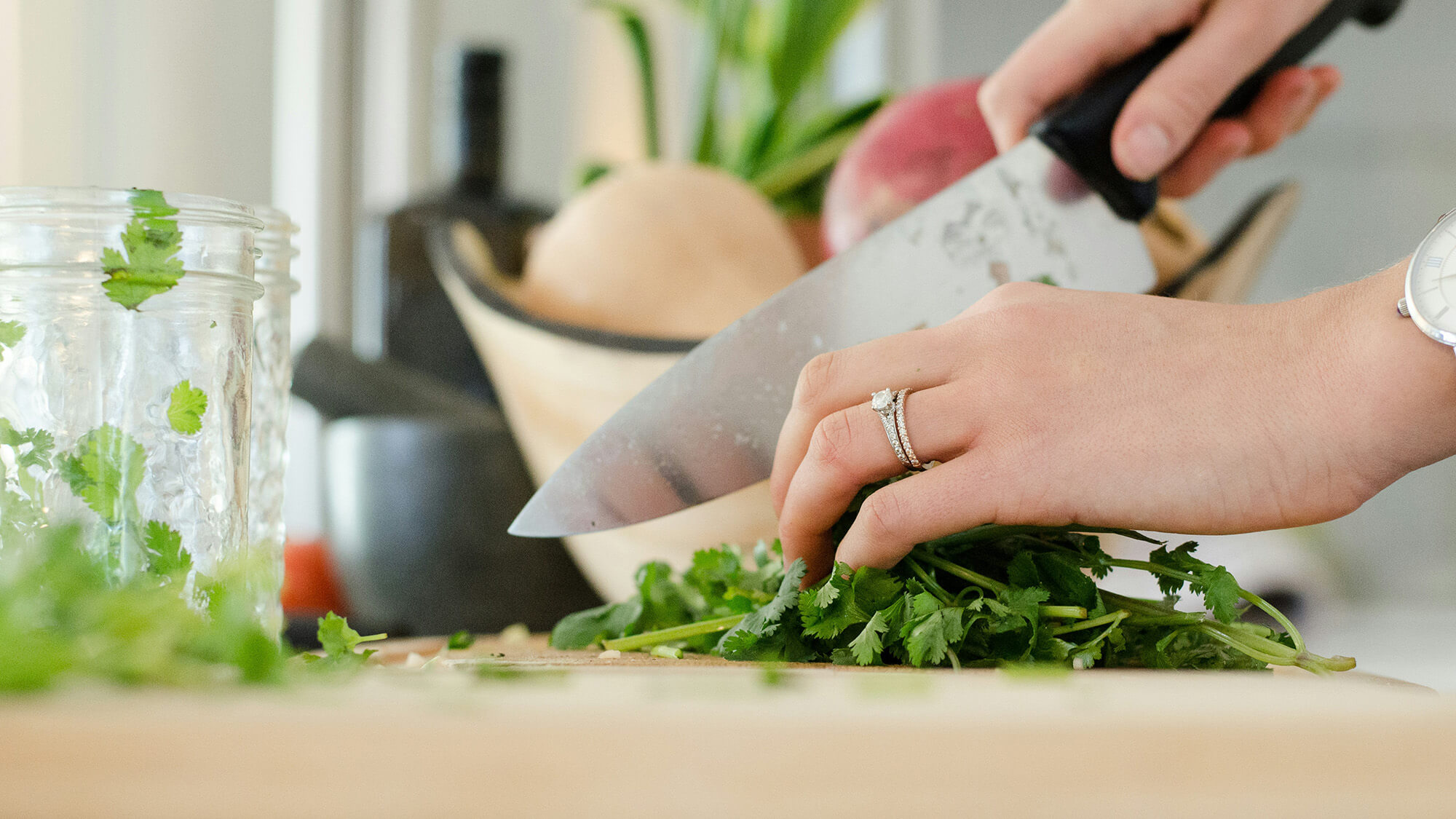 Woman in kitchen chopping and preparing food.