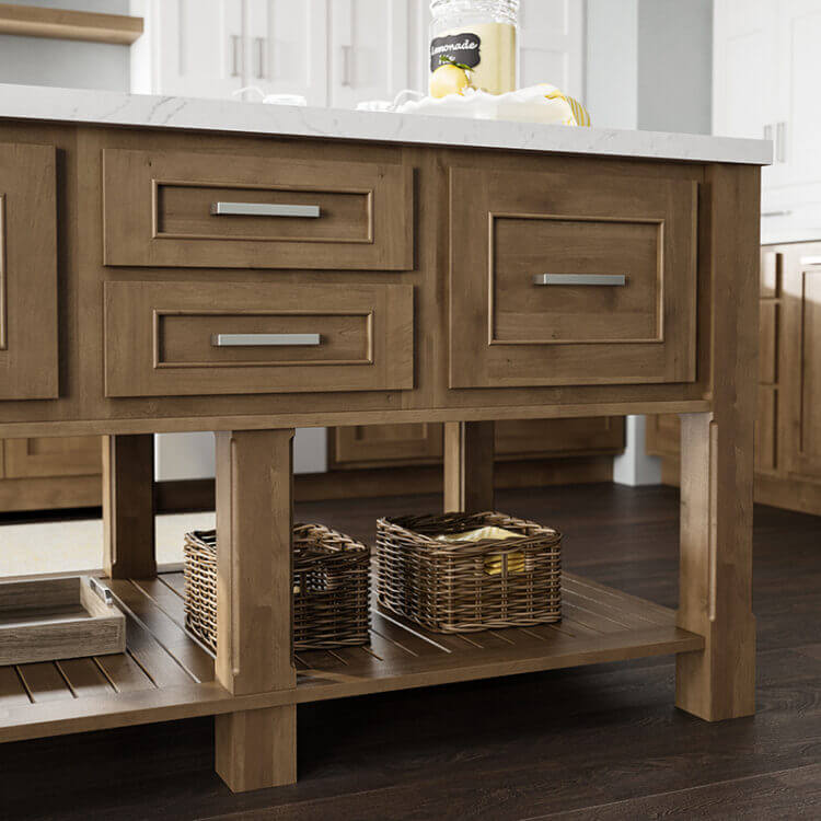 A kitchen table styled island with standard overaly cabinet doors with a light stained wood finish. A large floor shelf under the kitchen island offers space for decorative storage.