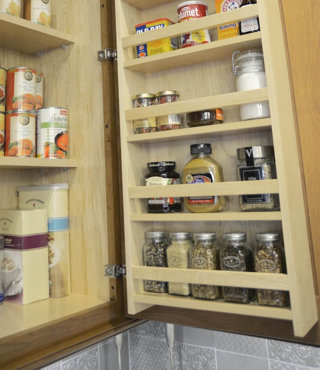 A traditional Cabinet Door Spice Rack from Dura Supreme offers convenient added storage in a wall cabinet in a traditional style kitchen from Dura Supreme Cabinetry.