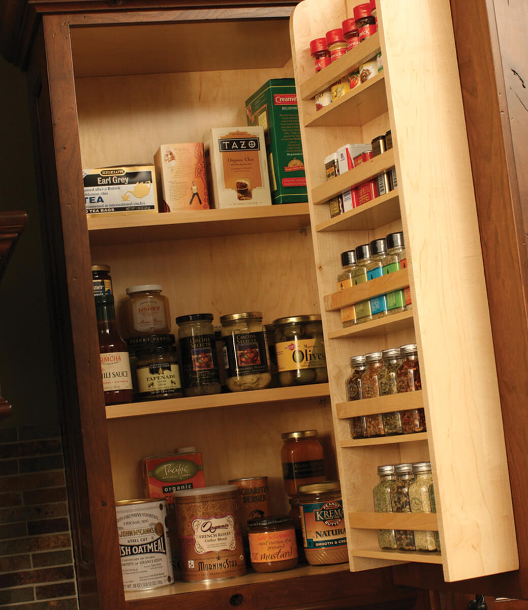 A traditional wall cabinet door spice rack from Dura Supreme Cabinetry stores row after row of spices.