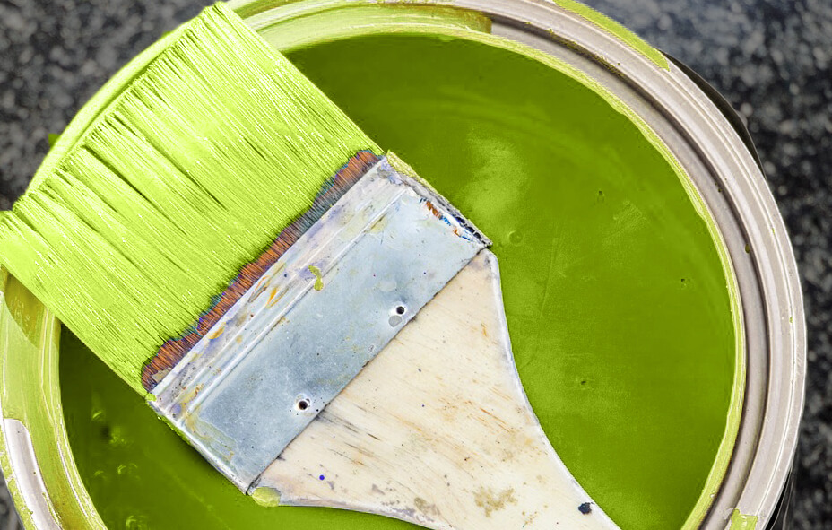Selecing a custom paint color for kitchen cabinets. Bright green paint can and paint brush.