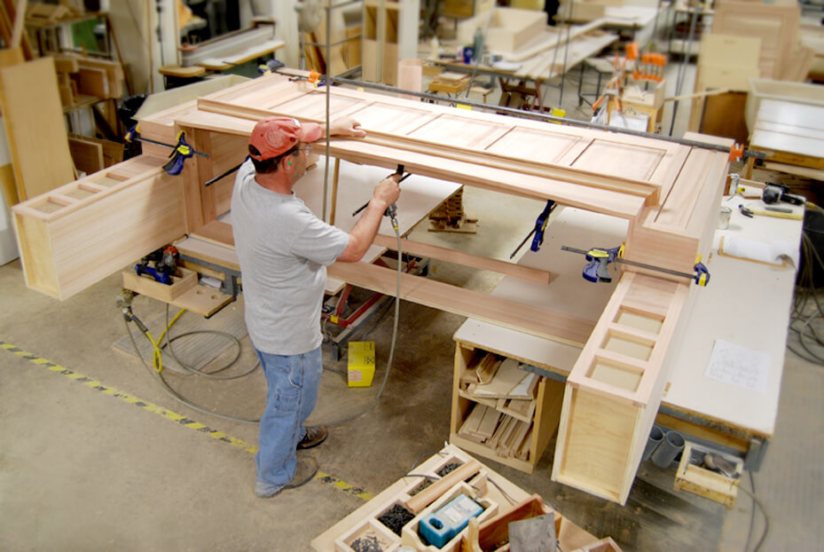 One of our Master Craftsman constructing a Dura Supreme Wood Hood. Dura Supreme Master Builder working on the molding details of a large wood hood.