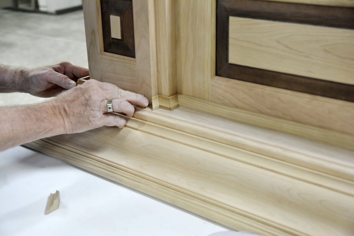 Dura Supreme Master Builder working on the molding details of a large wood hood.