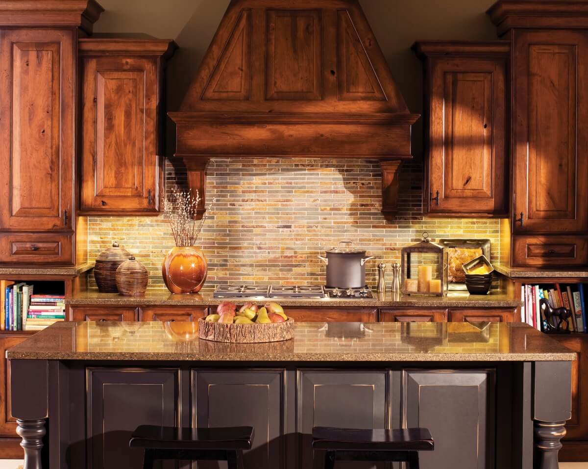 The backsplash tile in this mountain resort kitchen features a rough-hewn, stone texture and earthy coloring that pairs well with the rustic cabinets.