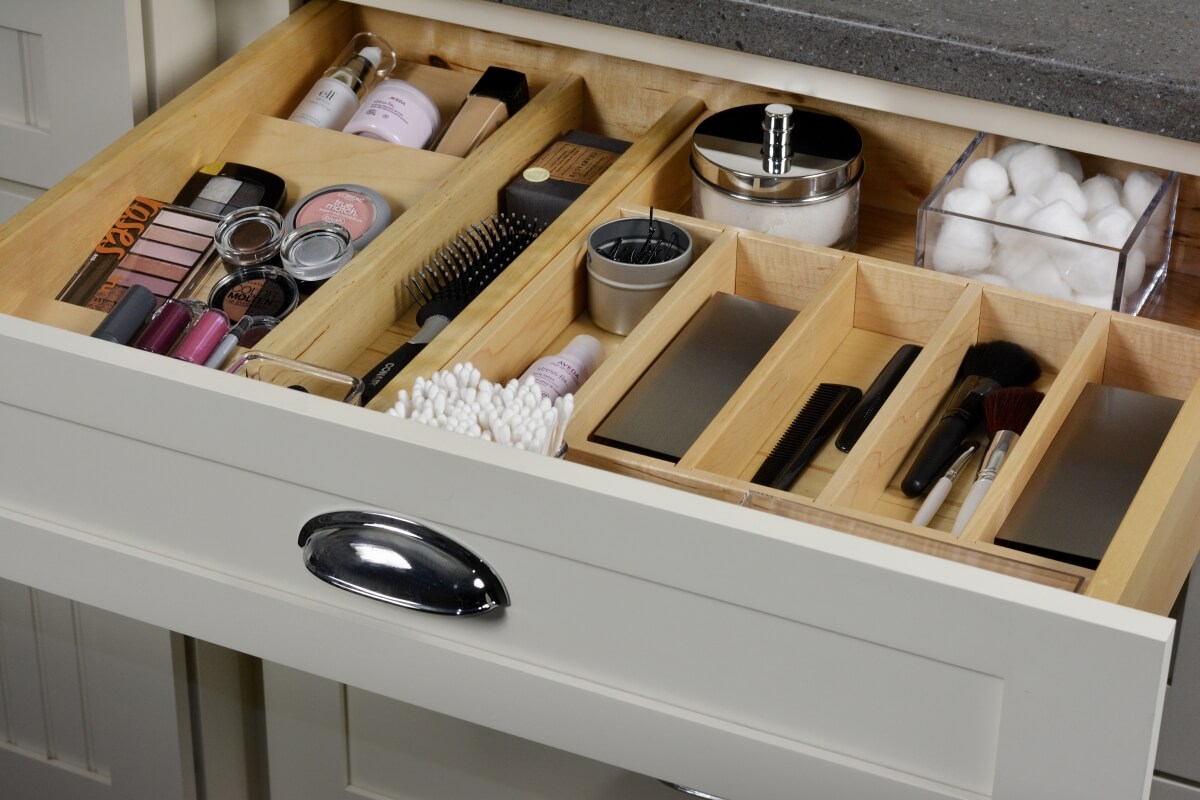 Wide drawer with organized divered for bathroom storage. Bathroom cabinets by Dura Supreme Cabinetry.