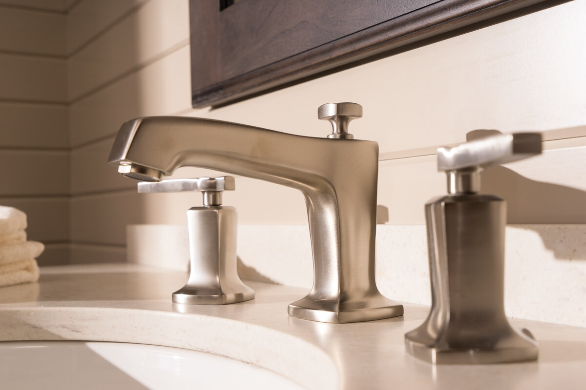 A close up of a bathroom sink and faucet with Dura Supreme bathroom cabinets.