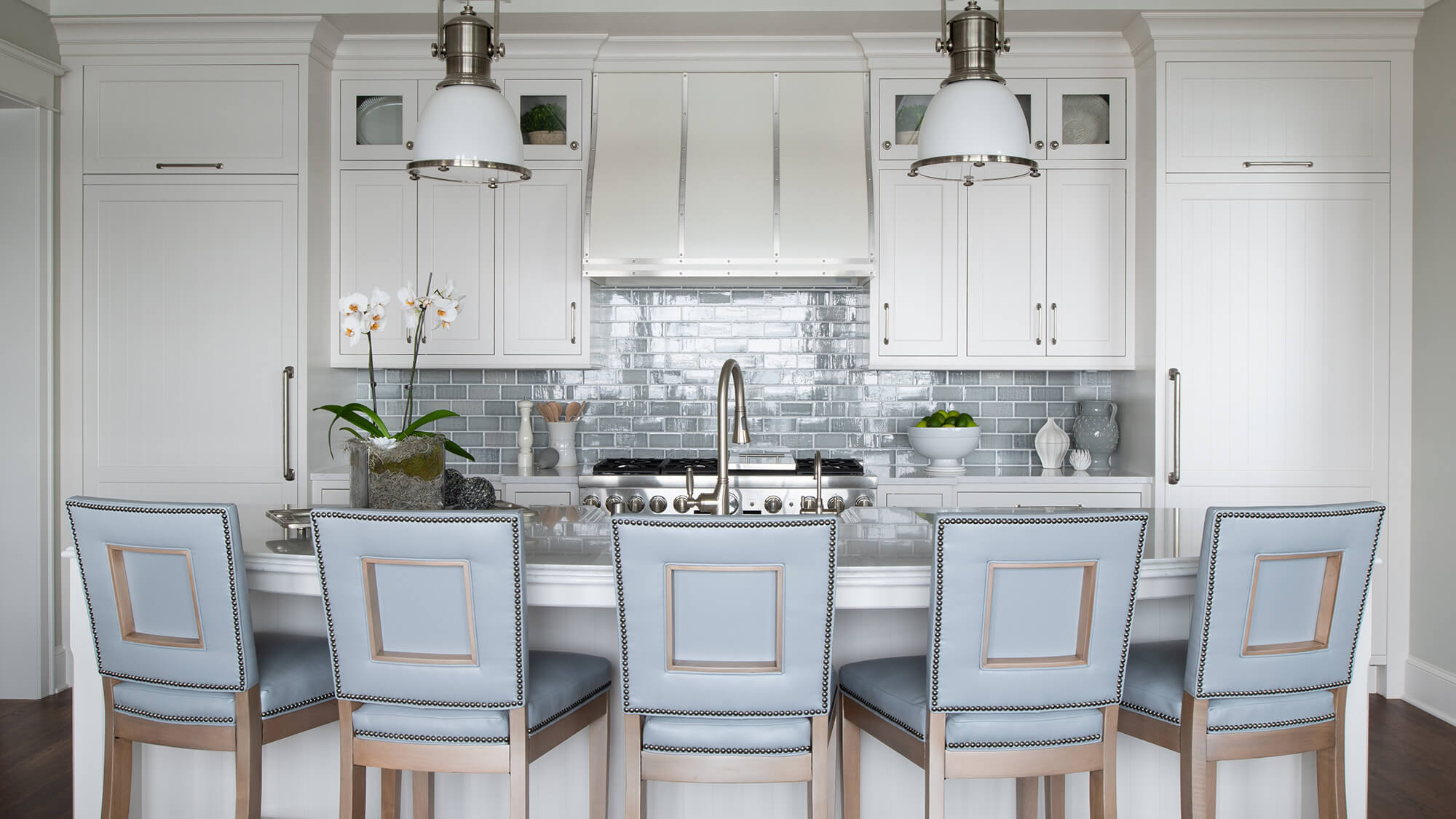 A symmetric kitchen design with two panel-ready refrigerators on opposite sides of the cooking range.
