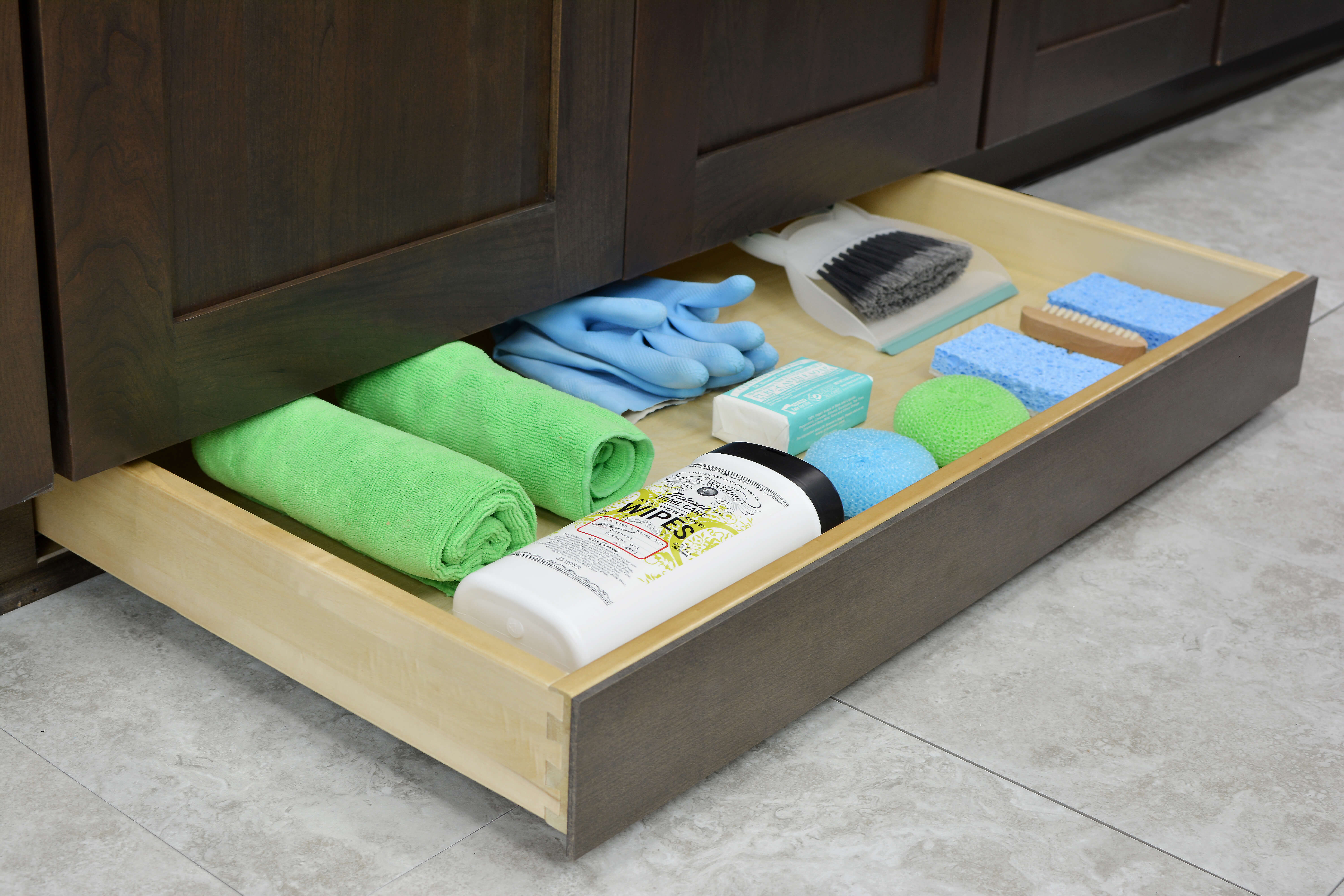 Miscellaneous items can find a home in a Dura Supreme Toe-Kick Drawer hidden at the foot of your cabinets. It is the perfect place for stashing cleaning supplies to they’re out of the way, yet close at hand.