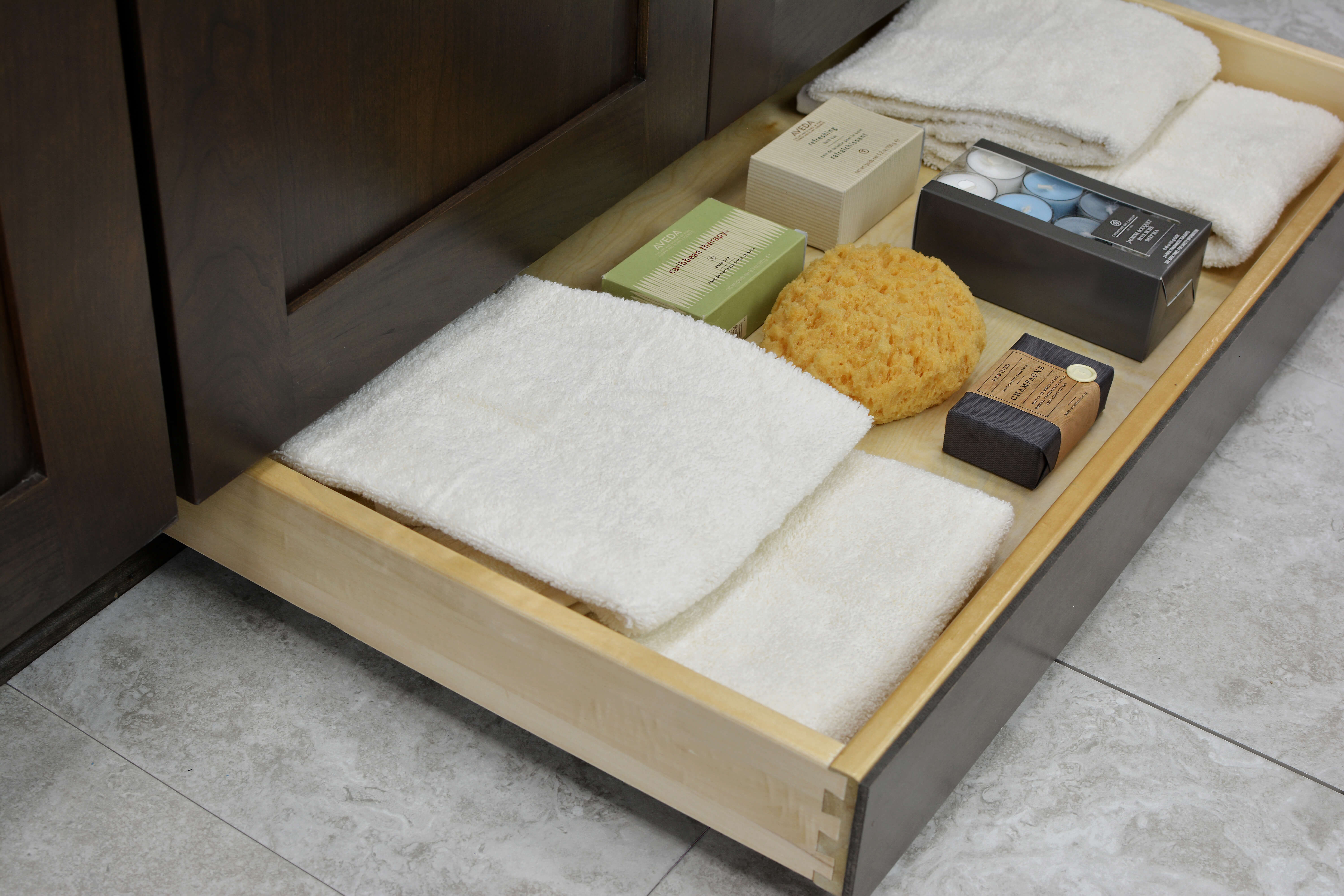 Miscellaneous items can find a home in a Dura Supreme Toe-Kick drawer hidden at the foot of your cabinets. It is the perfect place for stashing your spare bathroom supplies to they’re out of the way, yet close at hand when you need to restock.