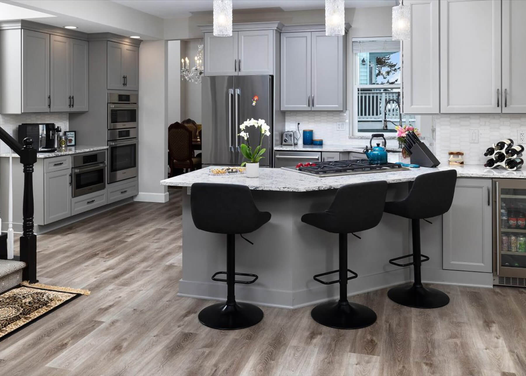 A gray G-Shaped kitchen design with an angled peninsula with a cooktop and seating for three.