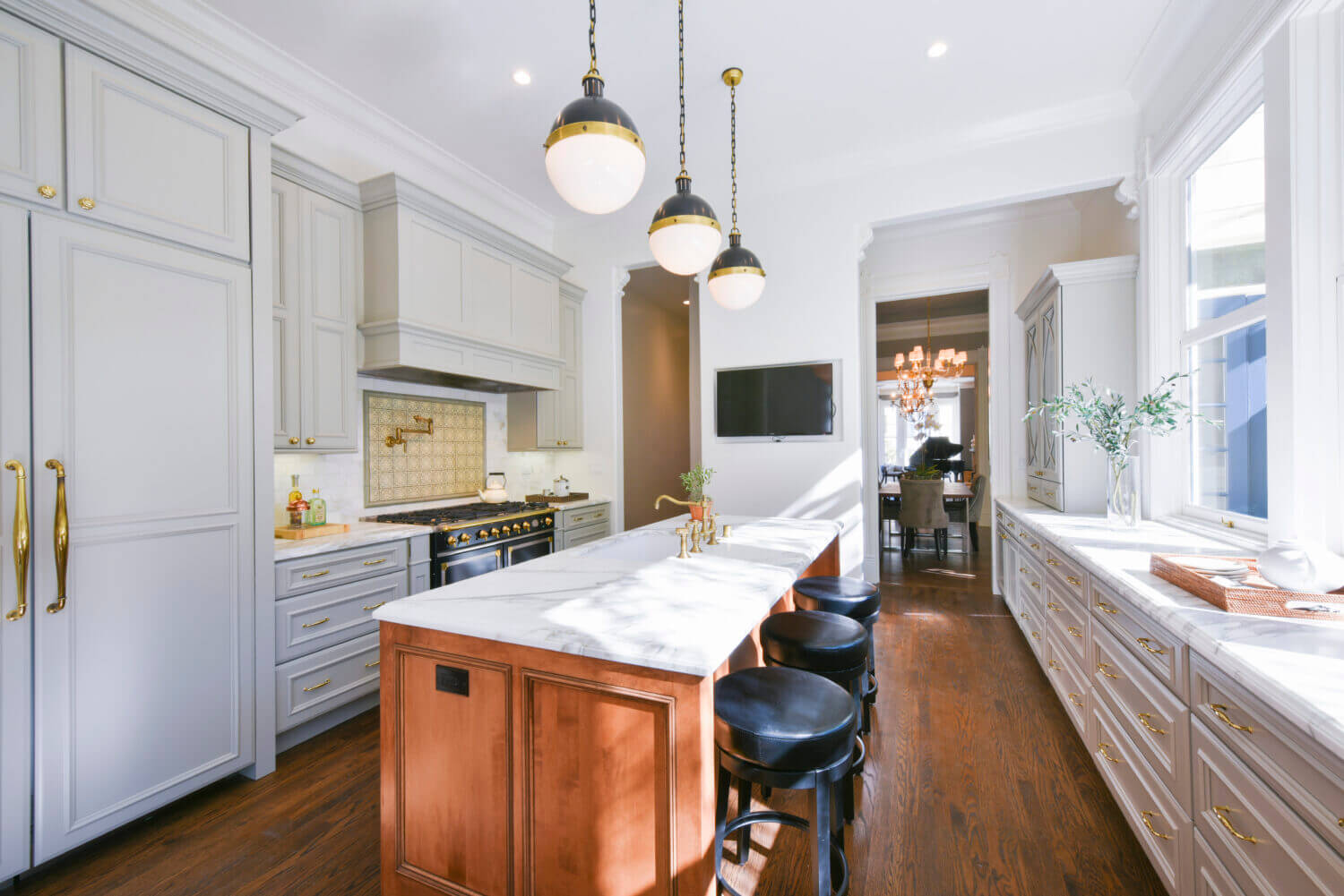 A pretty gray painted kitchen with a warm, red stained kitchen island.