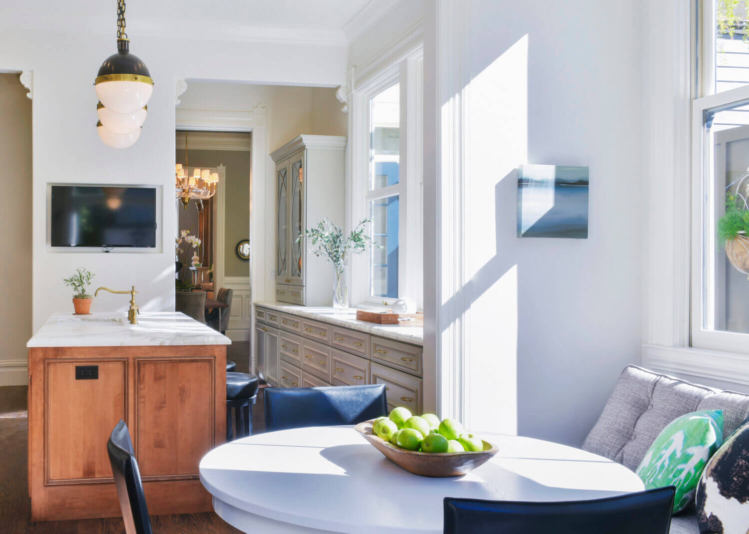 A traditional styled galley kitchen with a warm stained kitchen island and cool gray painted cabinets for the perimeter.