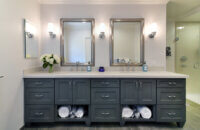 A dark painted bathroom vanity with two sinks and a furniture style.