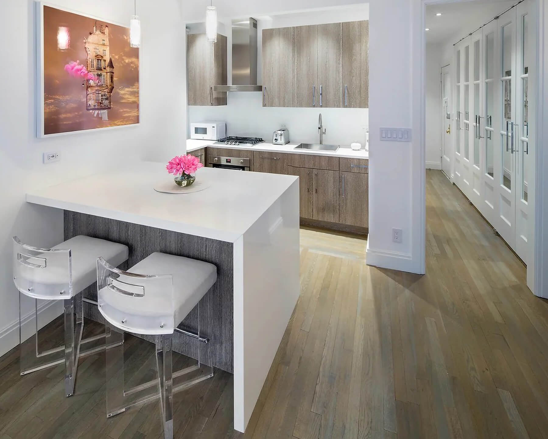 A small condo kitchen with a modern style and a waterfall kitchen peninsula cabinets with bar stool seating for two.