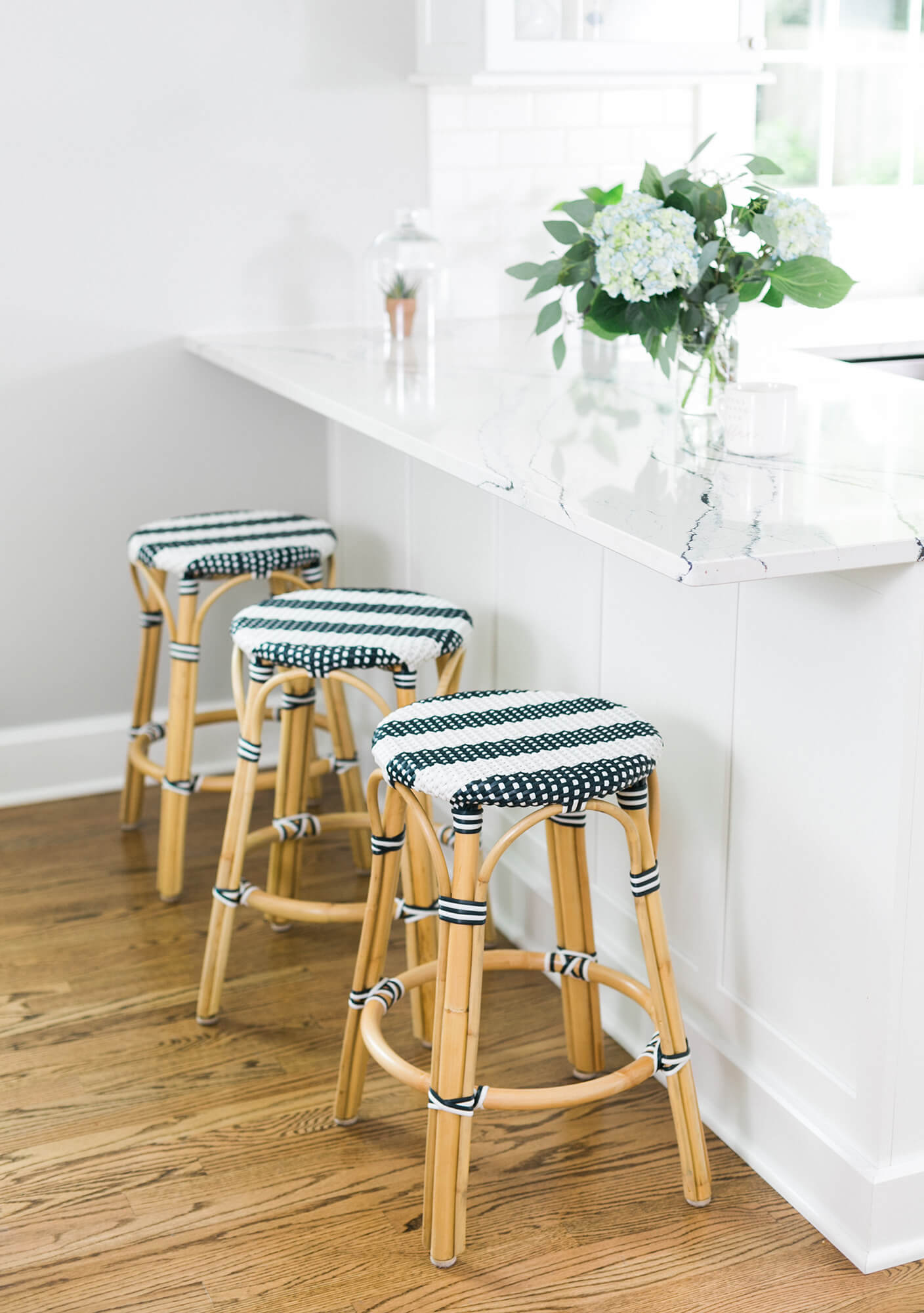 A beautiful, bright white kitchen design with a kitchen peninsula cabinets with a decorative back panel.