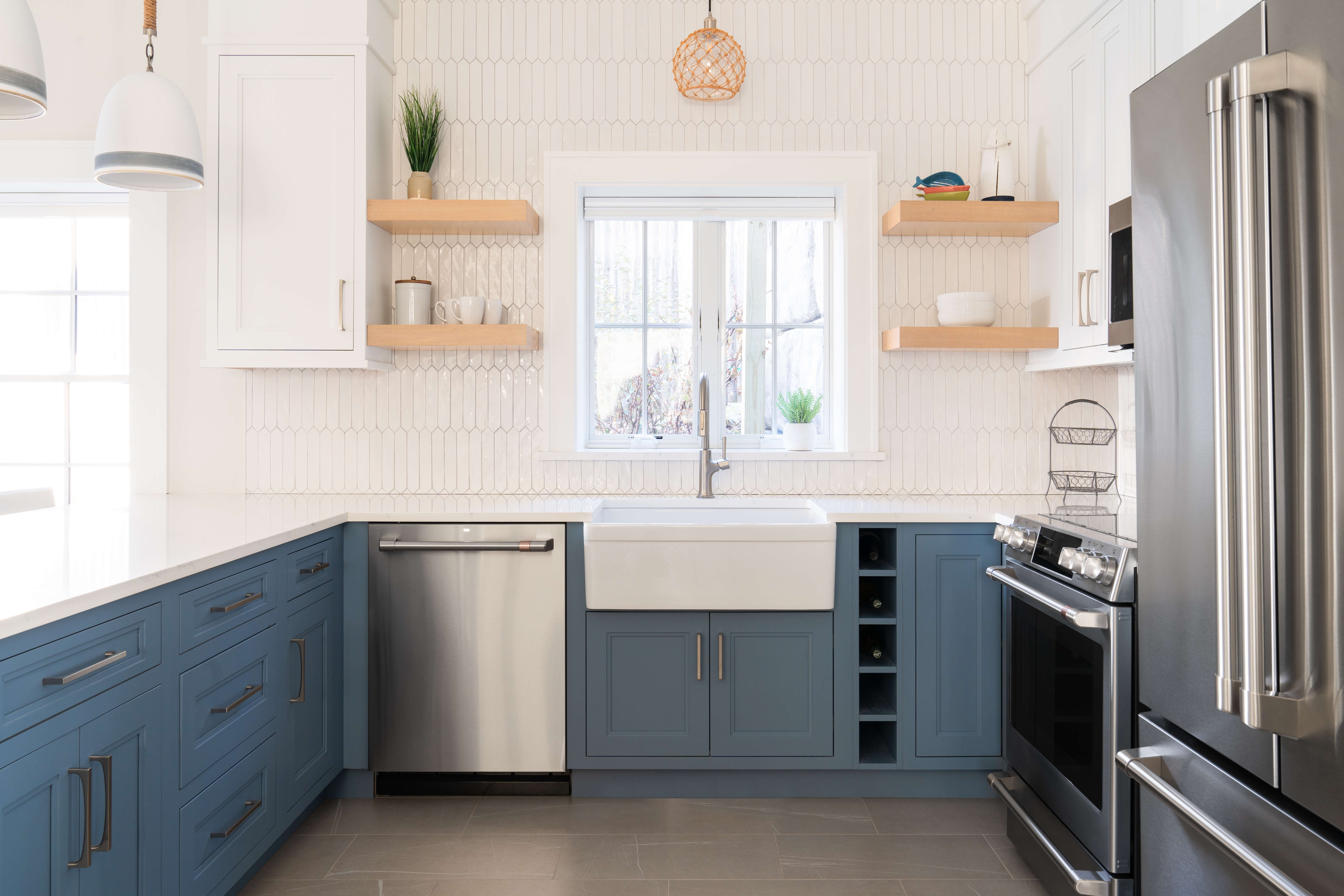 A white and navy blue peninsula kitchen design with U-shaped layout.