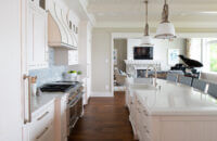 An East coast shingle styled kitchen with a symmetrical design using white painted inset cabinets and shiplap details.