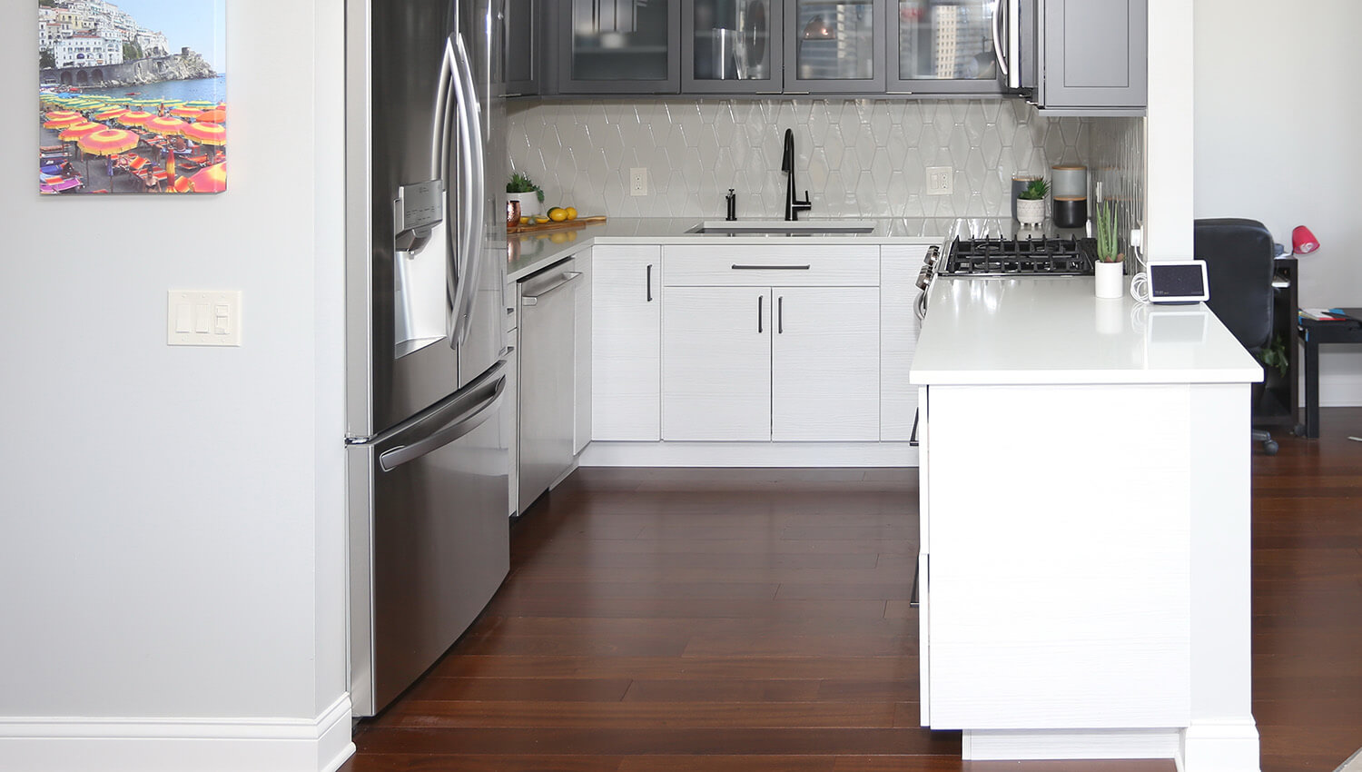 Are you looking for kitchen peninsula ideas for small kitchens? Check out this small kitchen with a highly functional kitchen peninsula. This two-toned kitchen features dark gray and white cabinets.