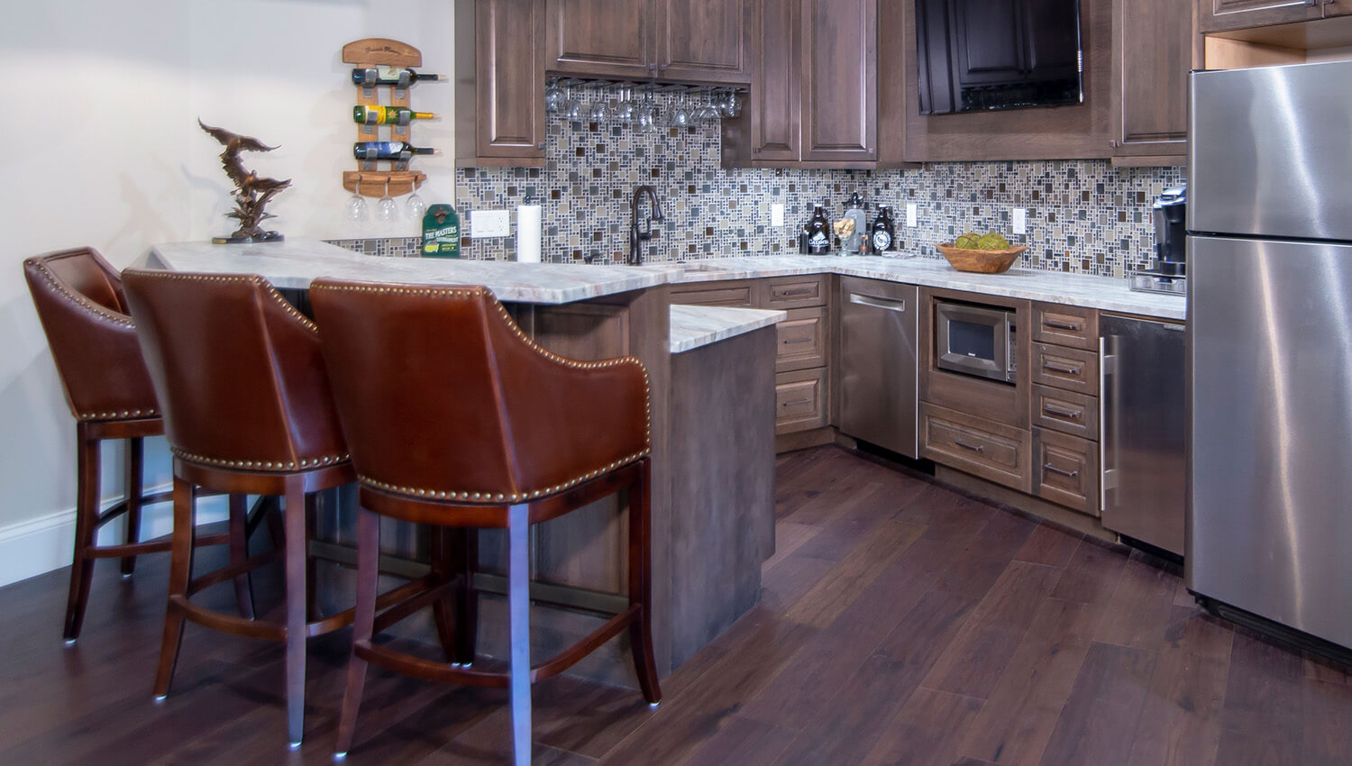 A large home bar area with a curved peninsula with bar height seating.