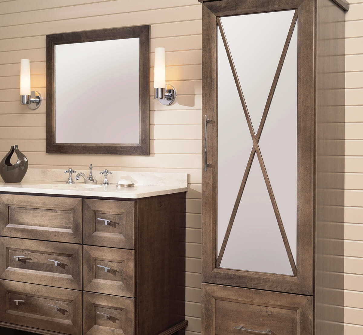 Light to Medium stained bathroom vanity and linen cabinet with an X pattern mullion door with a tall mirror glass insert in the cabinet door.