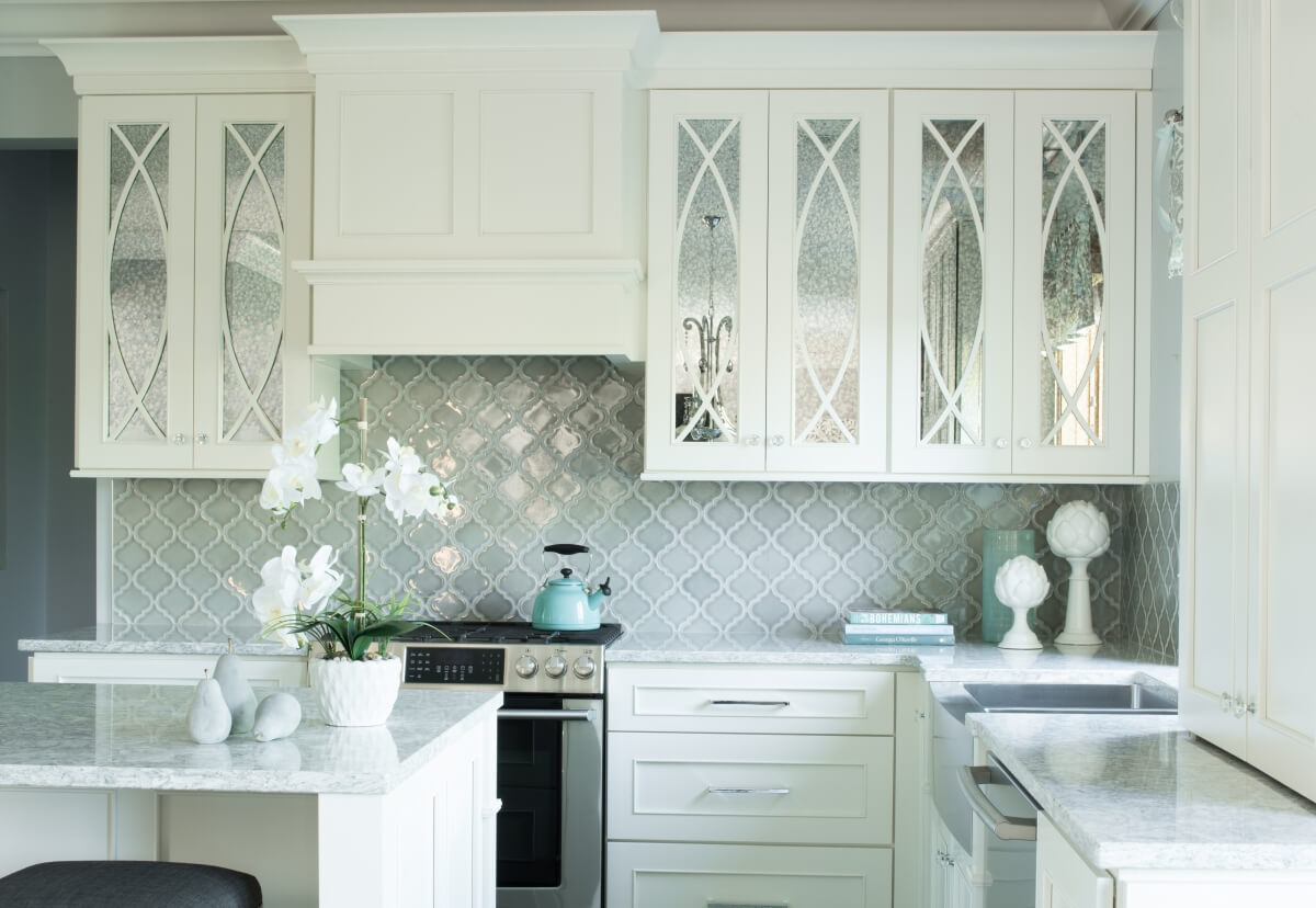 A white painted kitchen design with mullion cabinet doors and antique mirror glass insert.