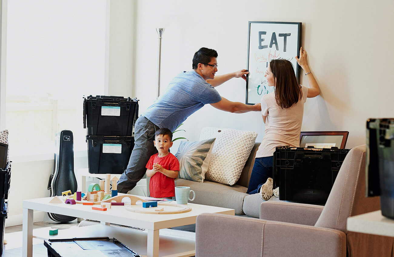 This couple is taking down a picture frame and safely packing up their breakable items to get ready for a kitchen and living room remodel. Before the demolition and installation process, you don’t want any valuables in exposed locations that could easily become damaged during the process, they should be secured or relocated for safekeeping.