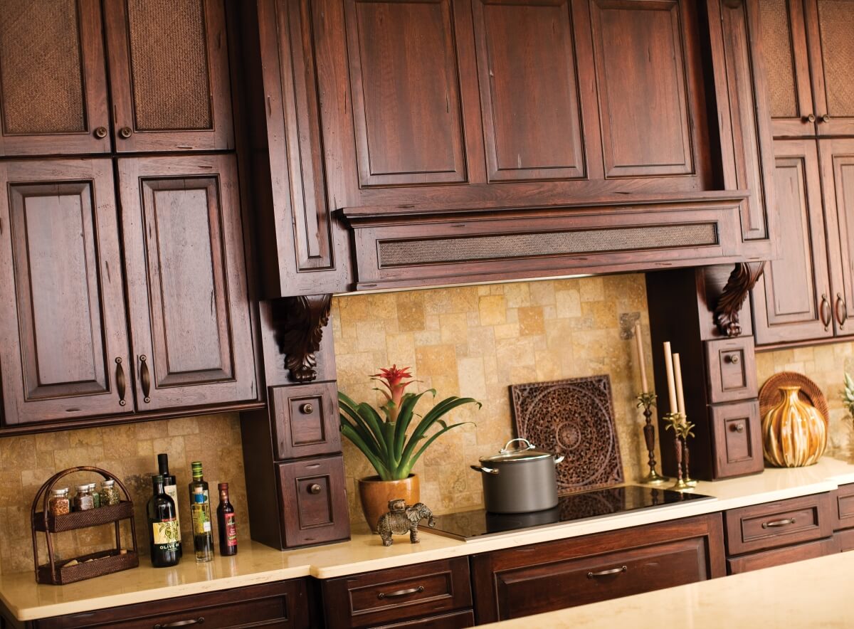 Grand wood hoods with intricate detail create a stunning focal point for a West Indies kitchen.