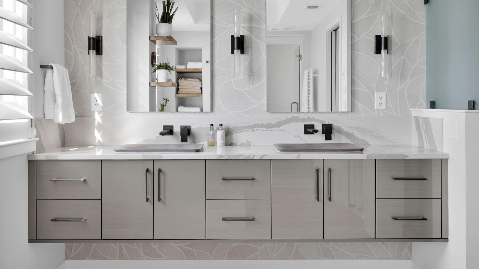 Floating custom bathroom vanity cabinets showcase a glossy metallic gray finish with a striking horizontal grain pattern for a sophisticated modern look. Slim black cabinet hardware contrasts beautifully against bright white walls, adding crisp contemporary style.
