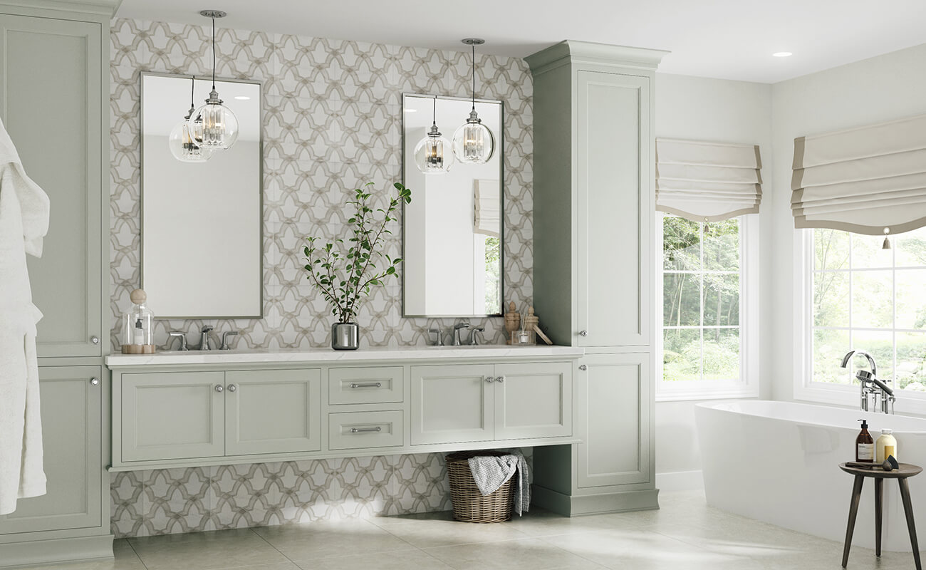 A modern and transitional style master bathroom with a floating vanity. The bathroom cabinets showcase a lovely light gray painted finish. The bathroom has large windows and a freestanding bath tub as well as a floor to ceiling backsplash that complements the color of the vanity cabinets.