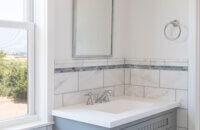 A gray painted sink vanity in a laundry room.