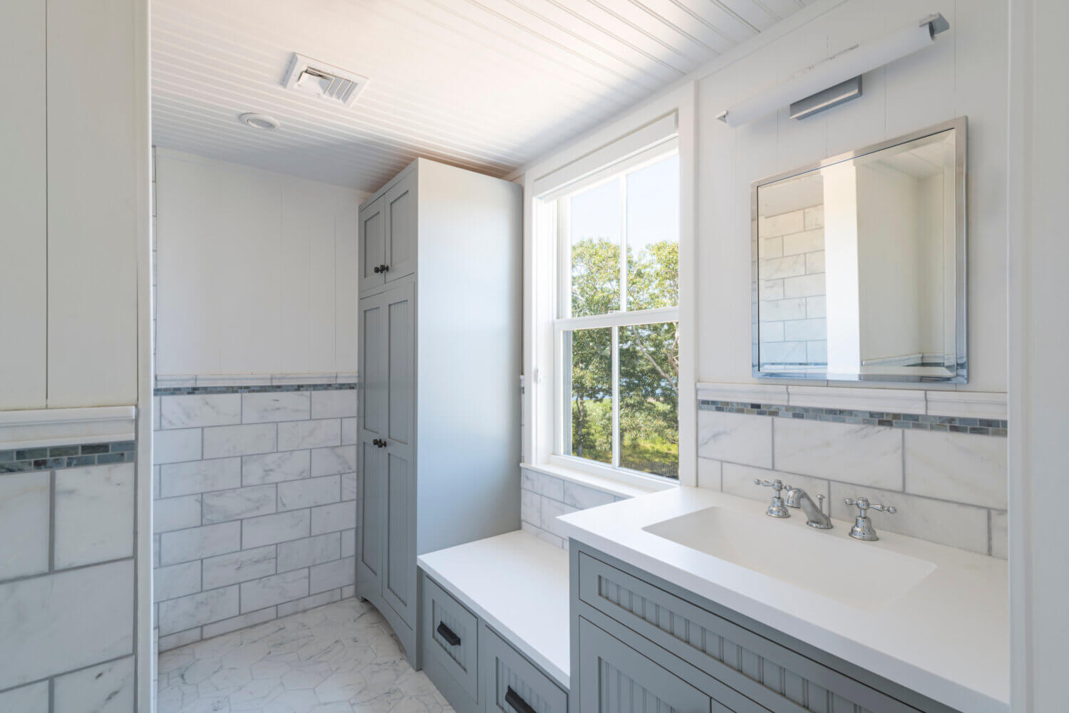 An all gray laundry room with a boot bench and locker.