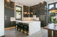 An ultra modern kitchen with contemporary black textured cabinets from Dura Supreme with futuristic lighting details and a wide waterfall kitchen island.