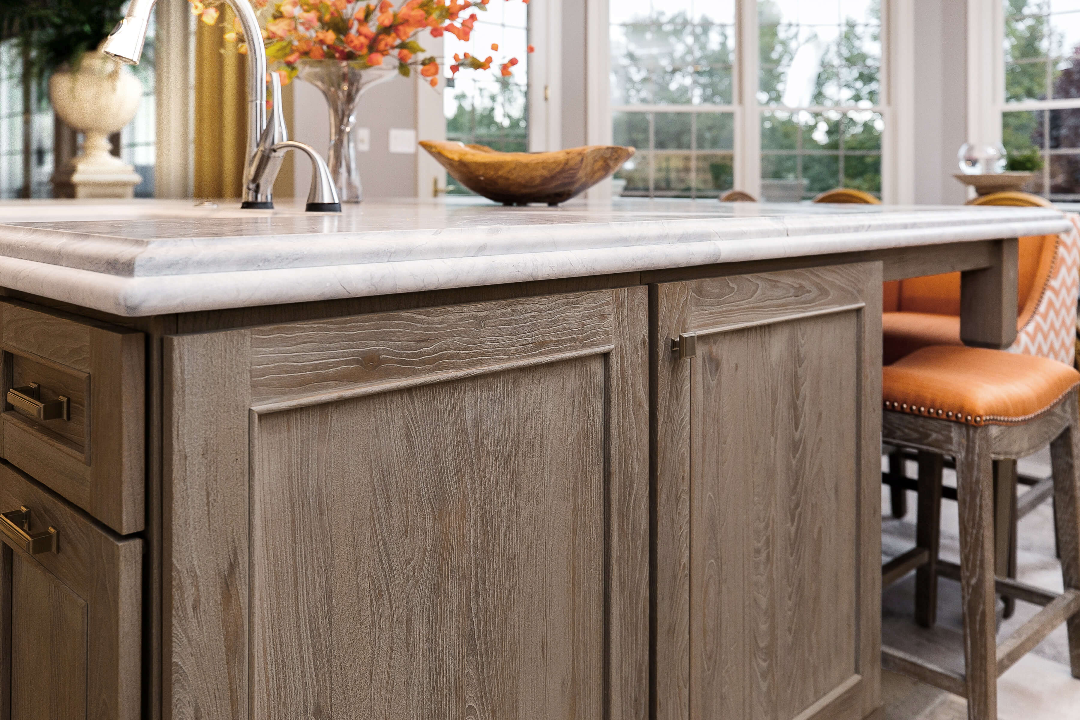A rustic weathered wood kitchen island with orange fall-inspired accents.