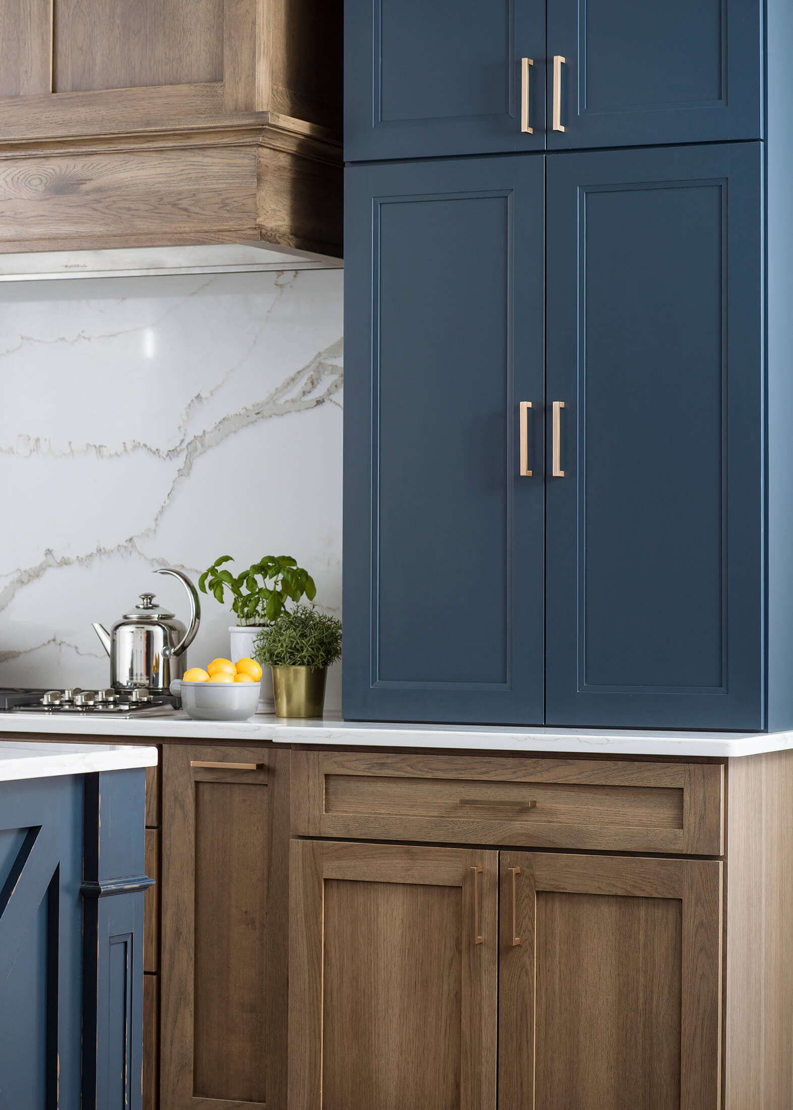 A navy blue and light stained hickory kitchen with a Modern Farmhouse style. Featuring Dura Supreme Cabinetry ins Sherwin-William's Gale Force blue paint color.