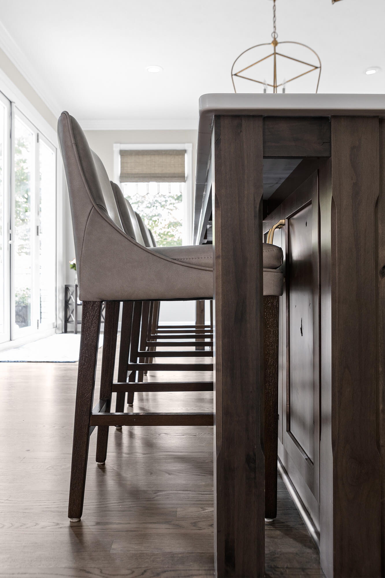 The bar stool is stained a similar color to match the kitchen island.