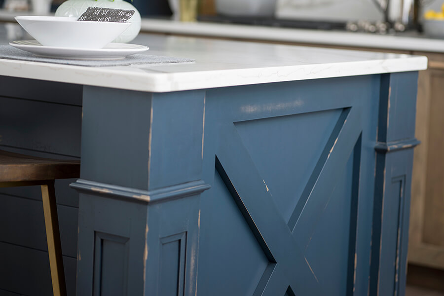 A furniture look kitchen island with an X patterned, modern farmhouse inspired end cap.