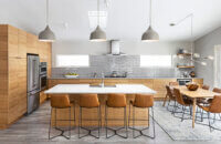 A beautiful kitchen with a light gray color palette contrasted by warm, natural bamboo cabinets with a modern & contemporary design style.