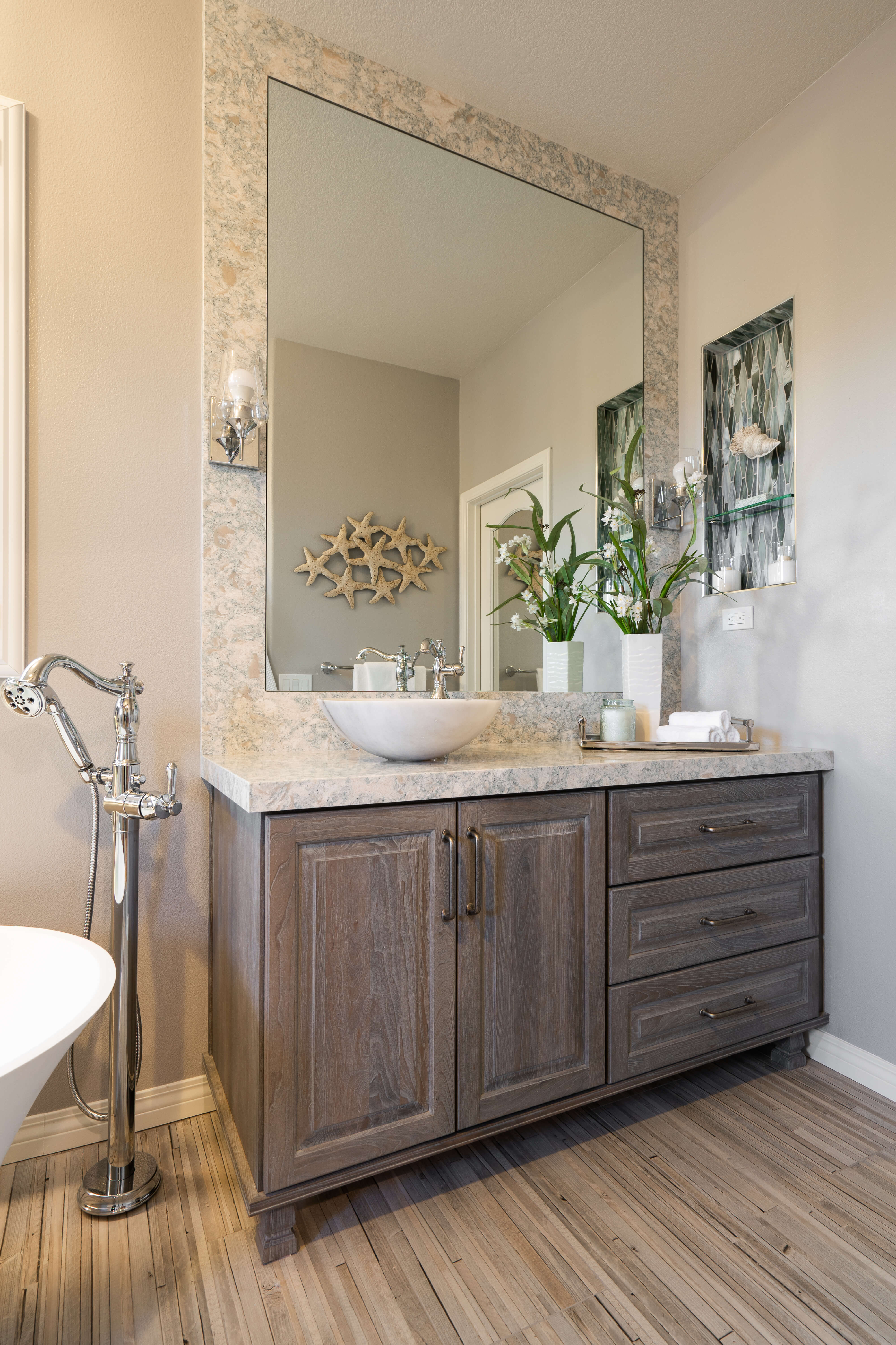 A traditional styled bathroom with gray stained cherry cabinet with furniture styled details and bun feet.