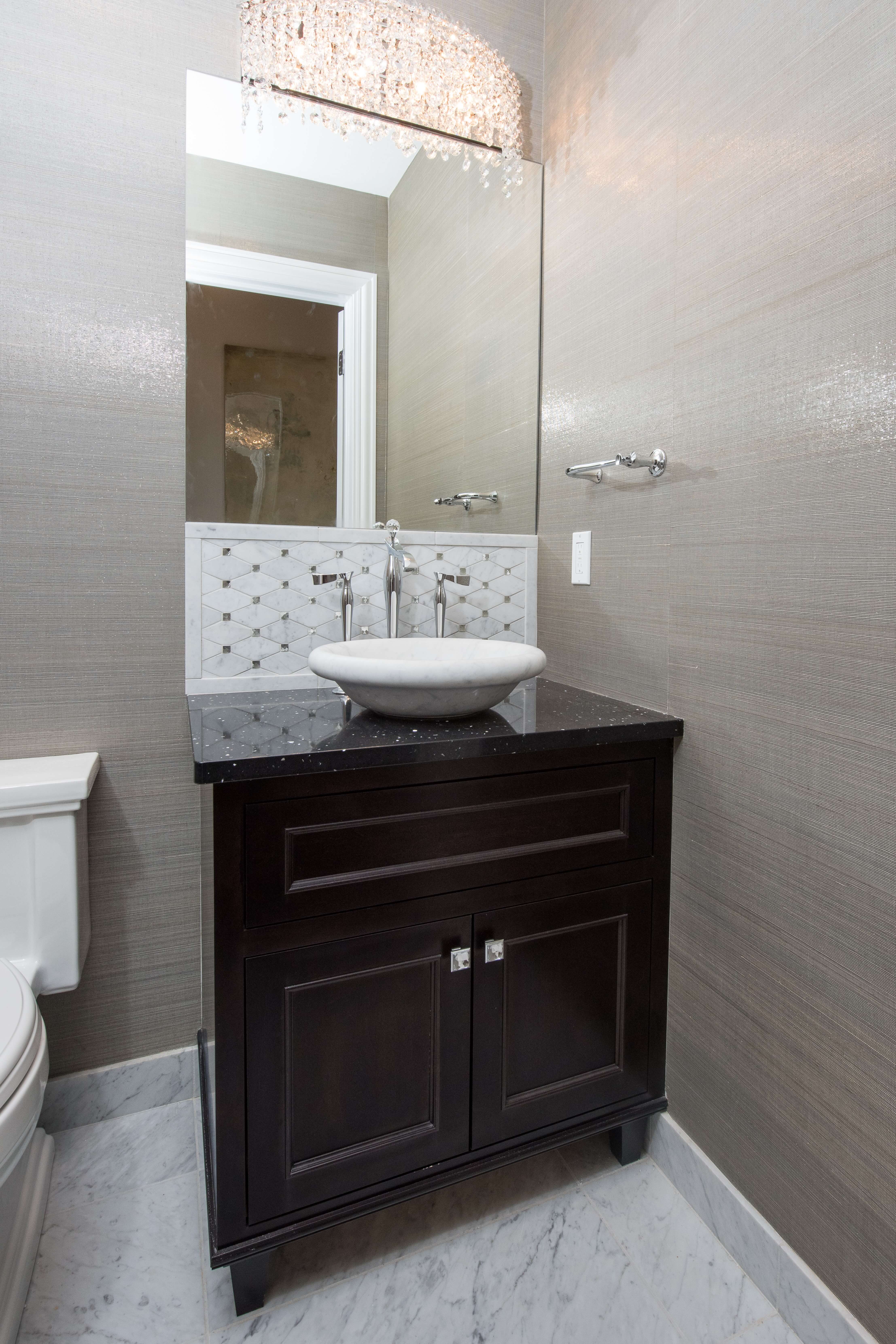 A dark, almost black stained bath vanity with a furniture style featuring custom bun feet/vanity legs.