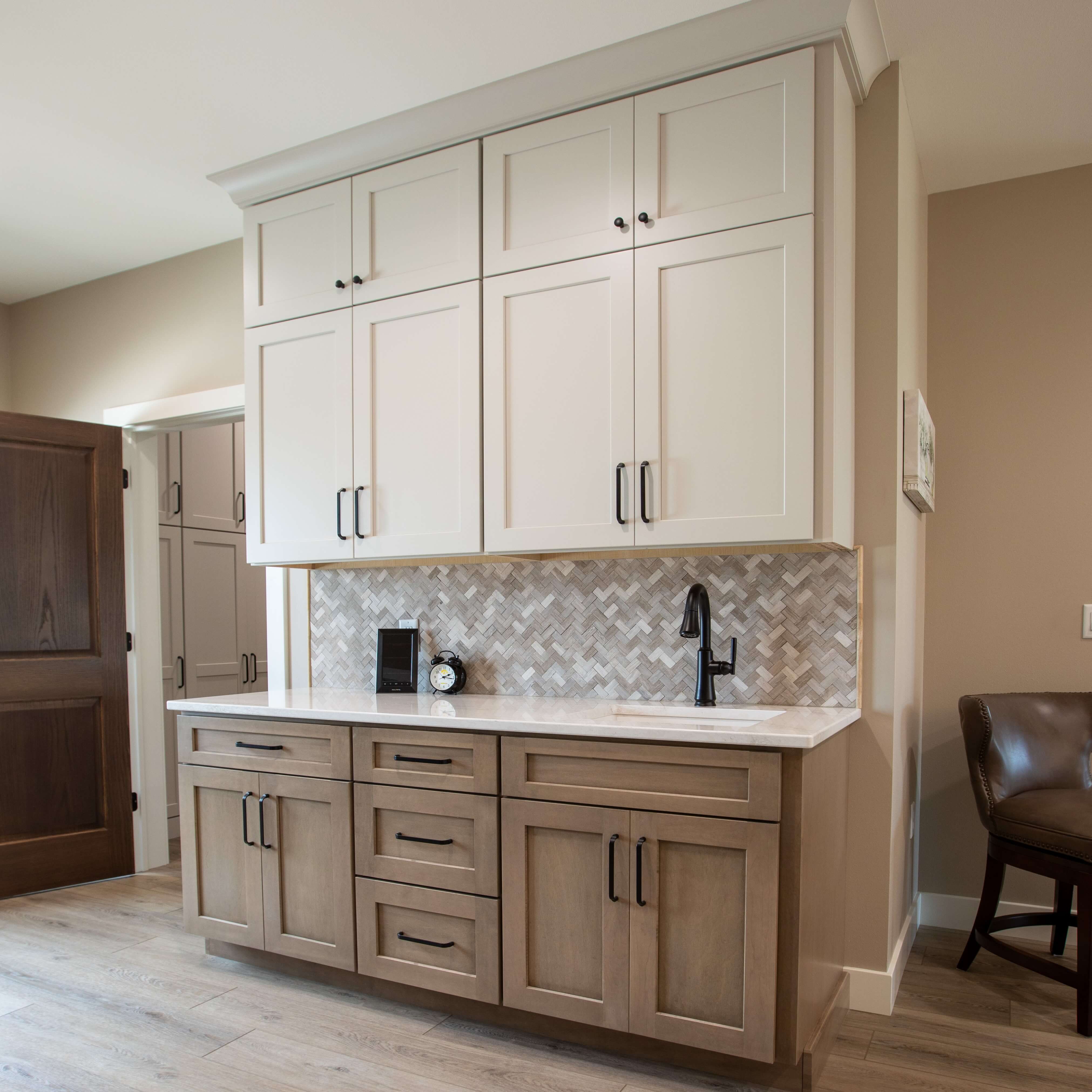 Tonal off-white to beige cabinets are used for the wall cabinets while a true-brown stain is used for the wood base cabinets.