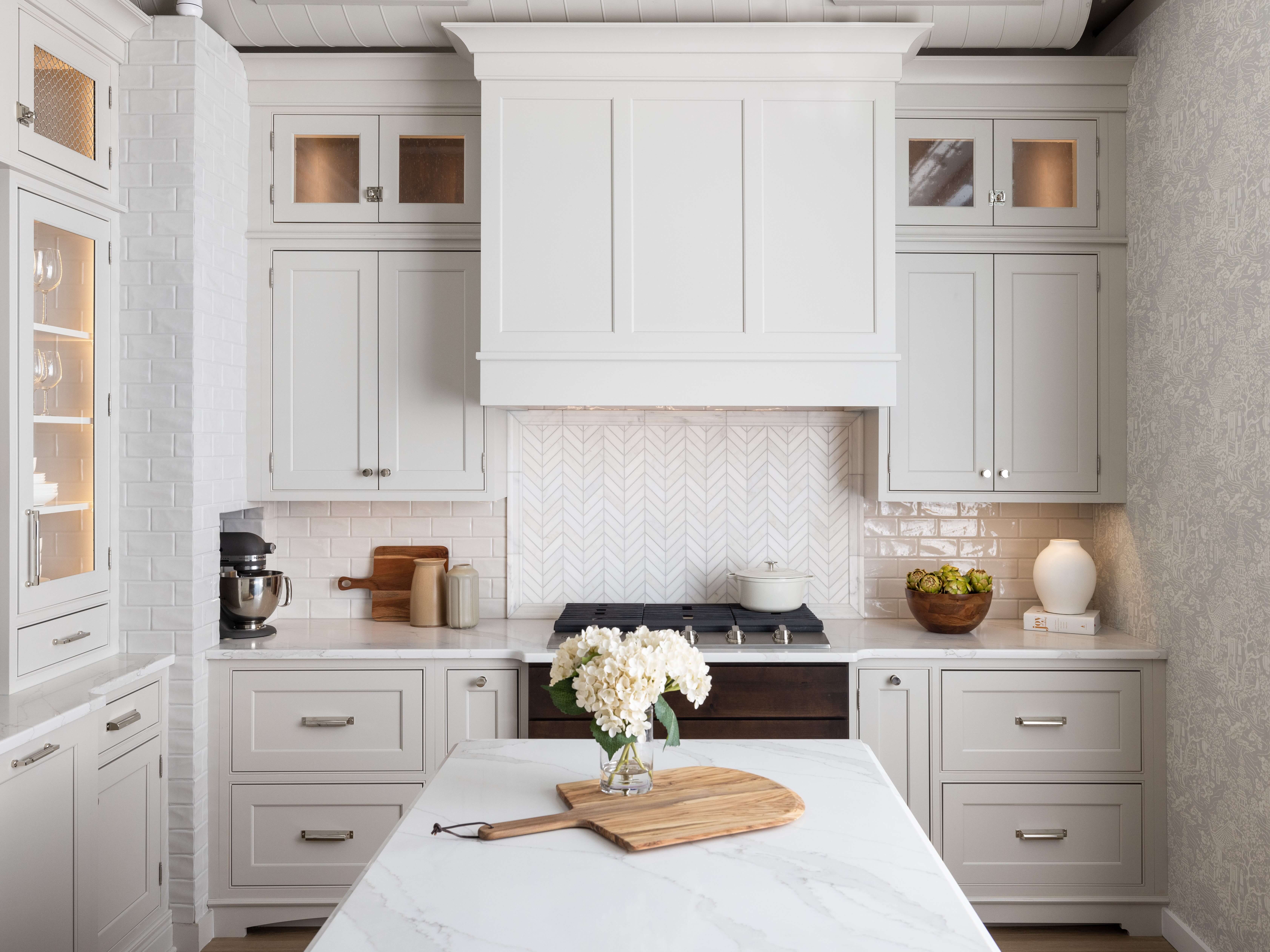 A stunning kitchen remodel in a historic building with an all-white color palette featuring a muted, tonal, off-white paint color for the cabinets.