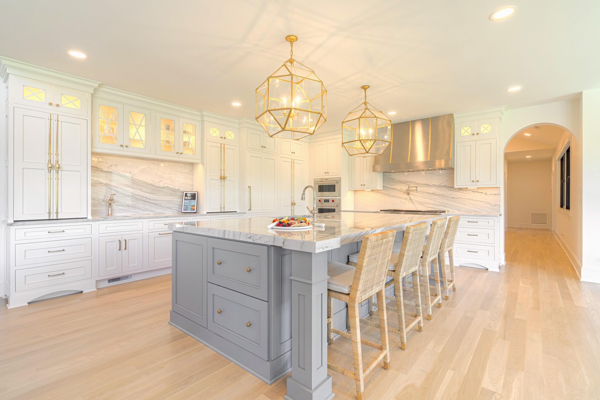 A chic and glamourous kitchen remodel with off-white cabinets with a tonal hue paired with a light gray kitchen island with lots of seating.