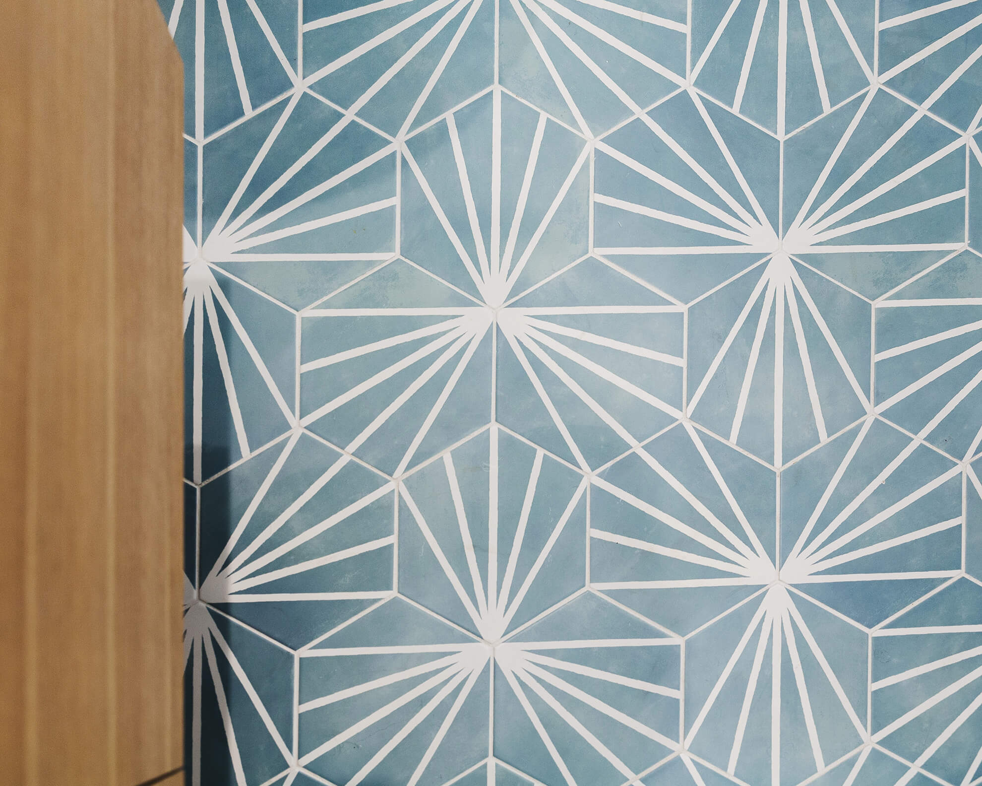 Trendy mosaic bathroom floor tiles with a beautiful light blue hue and fun geometric pattern.